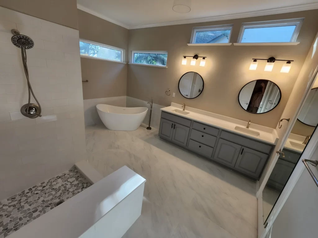 remodeled bathroom with double vanity tub and shower