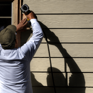 Contractor Installing new Siding with nail gun