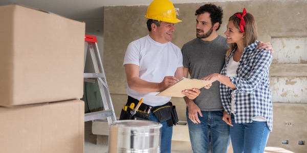 Contractor talking to a couple while remodeling their house